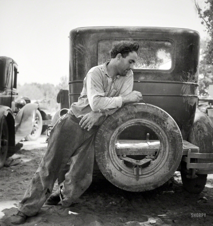 Photo showing: A Nice Round Number -- October 1935. Marysville, California. Agricultural worker in migrant camp figuring his year's earnings.