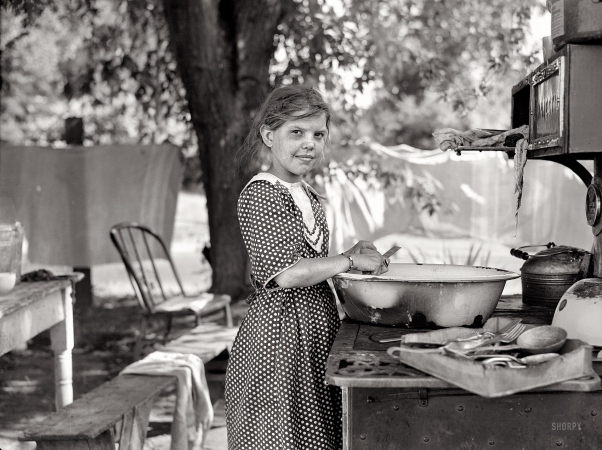 Photo showing: Growing Up Fast -- July 1936. Child of migratory fruit worker in tent camp at Yakima, Washington.
