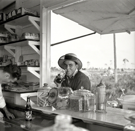 Photo showing: Playboy Pop Stand -- January 1937. Unmarried man who works in the packinghouse at Deerfield, Florida.