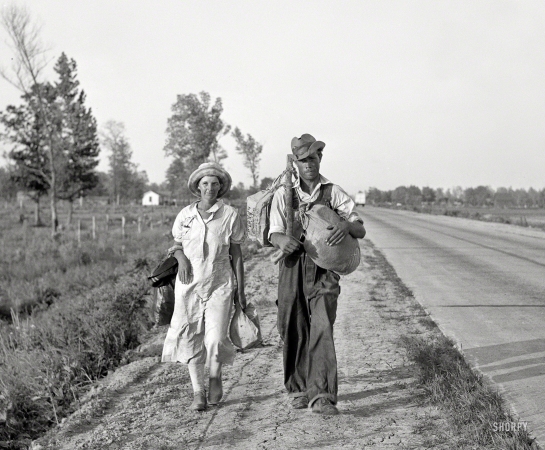 Photo showing: Not Cottoning -- May 1936.  'Damned if we'll work for what they pay folks hereabouts.' Crittenden County,
Arkansas. Cotton workers on the road, carrying all they possess in the world.