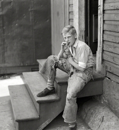Photo showing: Raggedy Andy -- July 1938. Young boy in Baltimore slum area.