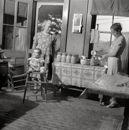 Photo showing: Beany Baby -- July 1940. Canning beans in farm kitchen near Bristol, Vermont.