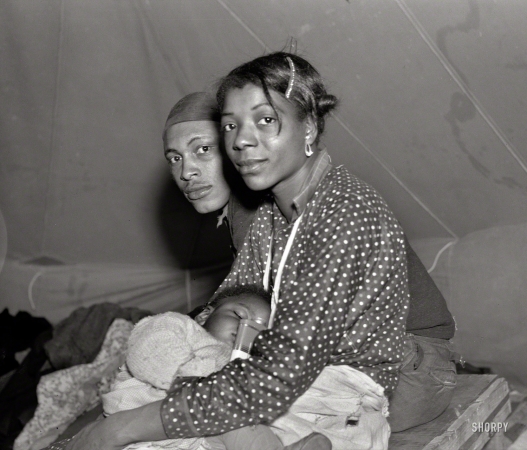 Photo showing: Refugees -- February 1937. Refugees from the 1937 flood their tent of the camp in Marianna, Arkansas.