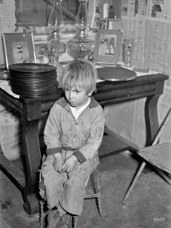 Photo showing: Media Room -- January 1939. Boy whose father is on relief. Family living in shanty at city dump. Herrin, Illinois.