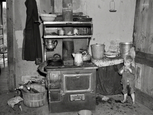 Photo showing: Kitchen Nightmare. -- June 1937. Child of Earl Taylor in the kitchen of their home near Black River Falls, Wisconsin.