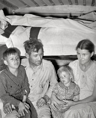 Photo showing: Family Time -- February 1939. White migrant family in trailer home near Edinburg, Texas.