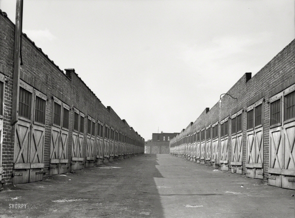 Photo showing: Charm City Garages -- July 1938. Garages in alley behind row houses. Baltimore, Maryland.