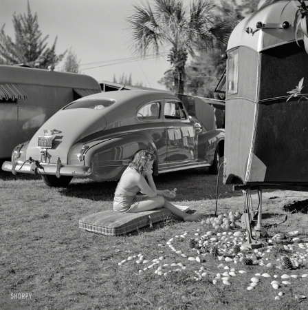 Photo showing: Trailer Queen -- January 1941. Guest at Sarasota, Florida, trailer park, beside her garden made of shells and odds and ends.