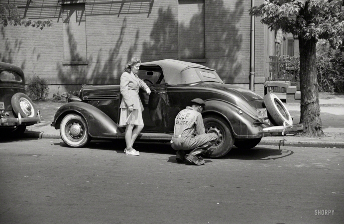 Photo showing: Gulf Service -- Spring 1942. Girl having her tire changed in Southeast Washington.