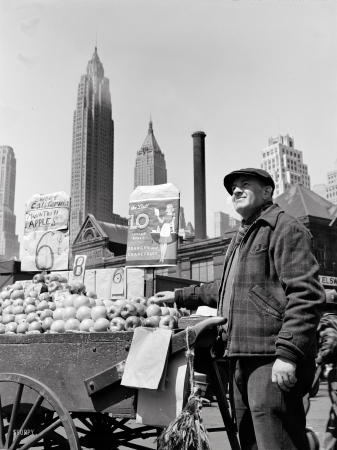 Photo showing: Apples and Oranges -- Pushcart fruit vendor at the Fulton Fish Market, New York, May 1943.