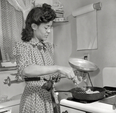 Photo showing: Skillet Dinner -- March 1942. Jewel Mazique cooking dinner after a hard day's work in the Library of Congress.