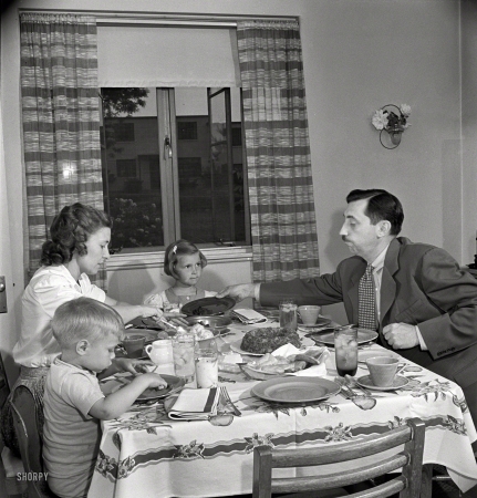Photo showing: A Place at the Table -- May 1942. Greenbelt, Md. Federal housing project. Mr. and Mrs. Leslie Atkins, Ann, and Pierce Atkins having supper.