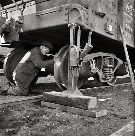 Photo showing: Jacked -- November 1942. Chicago, Illinois. Jacking up a car on the repair tracks at an Illinois Central Railroad yard.