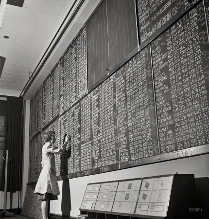 Photo showing: Information Room -- January 1943. Chicago, Illinois. Mrs. Marie Griffith, manager of the information room,
at one of the boards listing rates to points all over the country at the Union Station.