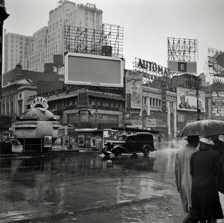 Photo showing: Saludos Amigos -- March 1943. New York, N.Y. Times Square on a rainy day. Now playing: Disney's Saludos Amigos.