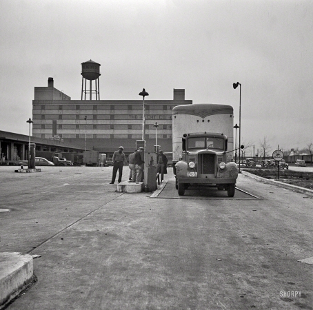 Photo showing: Truck Stop -- March 1943. Washington, D.C. Transport refueling at Hecht Co. warehouse on New York Avenue.