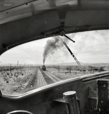 Photo showing: Oil and Water -- March 1943. Ash Fork, Arizona (vicinity). Passing an eastbound freight
on the Atchison, Topeka & Santa Fe between Winslow and Seligman. 