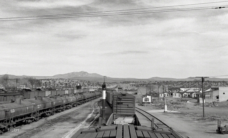 Photo showing: Eats, Liquors -- March 1943. Ash Fork, Arizona. Pulling into the Atchison, Topeka & Santa Fe railyard.