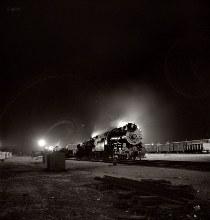 Photo showing: Night Train -- March 1943. Barstow, California. A view of the Atchison, Topeka & Santa Fe yard at night.