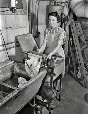 Photo showing: Basement Laundry -- Sept. 1942. Rochester, New York. Mrs. Babcock doing the family laundry with an electric washing machine and a wringer.