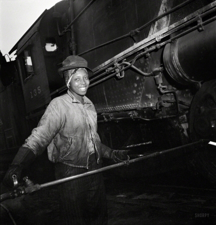 Photo showing: Fifty-Eight an Hour -- June 1943. Pitcairn, Pennsylvania. Mrs. Bernice Stevens of Braddock, Pa., mother of one,
employed in the engine house of the Pennsylvania Railroad, earns 58 cents per hour.
She is cleaning a locomotive with a high pressure nozzle. Her husband is in the Army.