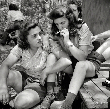 Photo showing: Pit-Women -- June 1943. Turkey Pond, near Concord, New Hampshire. Women employed by Department of Agriculture
timber salvage sawmill. Ruth DeRoche and Norma Webber, 18-year-old 'pit-women,' relaxing after lunch.