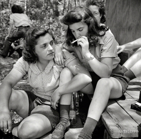 Photo showing: Pit-Women -- June 1943. Turkey Pond, near Concord, New Hampshire. Women employed by Department of Agriculture
timber salvage sawmill. Ruth DeRoche and Norma Webber, 18-year-old 'pit-women,' relaxing after lunch.