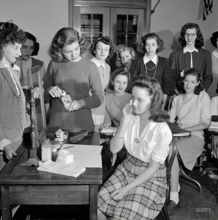Photo showing: Asset Management -- October 1943. Washington, D.C. Demonstration of the correct procedure in
applying street makeup. Home management class at Woodrow Wilson High School.