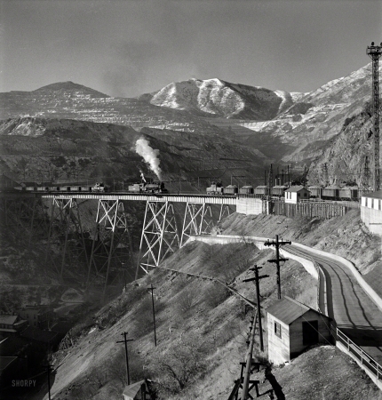 Photo showing: Copper Coming -- November 1942. Bingham Canyon, Utah. Ore trains on a
trestle bridge above an open-pit mine of the Utah Copper Company.