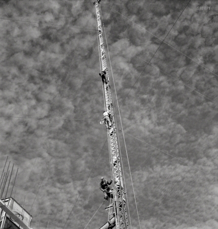 Photo showing: Upward Bound -- November 1942. Columbia Steel Company at Geneva, Utah. Rigging a pipe-setting derrick.