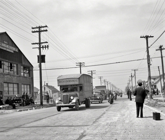 Photo showing: Moving Day -- February 1942. Detroit, Michigan. After a riot at the Sojourner Truth Homes, a new
U.S. federal housing project, caused by white neighbors' attempt to prevent Negro tenants
from moving in, moving vans convoyed by police department moving Negroes' furniture. 