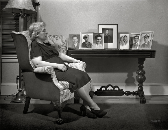 Photo showing: All My Children -- Spring 1942. New Bedford, Massachusetts. Portuguese mother with pictures of her sons, who are all in service.