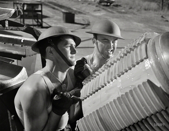 Photo showing: Coastal Defense -- March 1942. Virginia Beach, Va. Fort Story coast defense. A tough job for
soldiers: shoving the breech block of the giant howitzer into place.