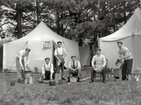 Photo showing: Gaiety Camp -- New Zealand circa 1910. Group men outside a tent with a sign reading 'The Gaiety Camp'.