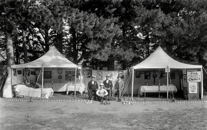 Photo showing: Dork Dynasty -- New Zealand circa 1910. Unidentified men between two open tents with Gaiety Camp sign. Sumner, Christchurch. 