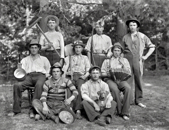 Photo showing: Kiwi-Haw: 1905 -- New Zealand circa 1905. Eight young men in ragtag clothing with accordion, pipes, gun and dog. Sumner, Christchurch.