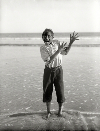 Photo showing: A Haka -- New Zealand, 1913. Maori boy performing a haka on the beach, Northland.