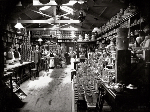 Photo showing: Take Rheumo -- 1890s New Zealand. Grocery shop interior, with staff, location unidentified.